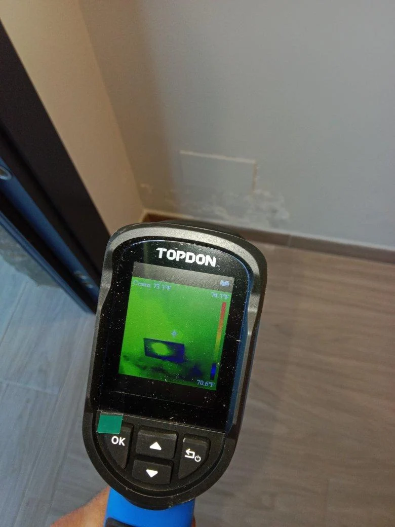 Cámara frente a una pared con daños de humedad durante una inspección