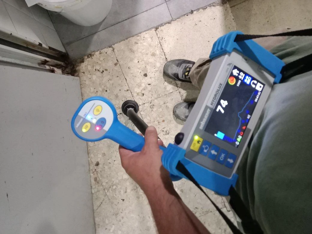 Equipo y sonda en una comprobación de fuga en el baño de un local