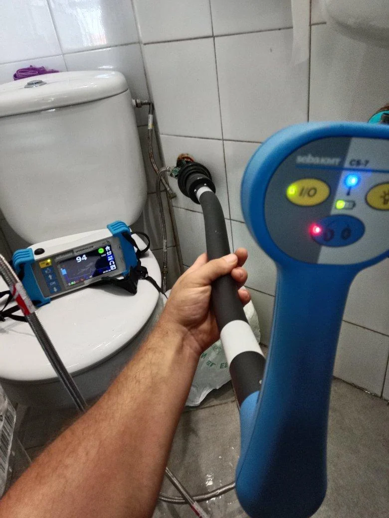Técnico utilizando una sonda para comprobar la pared de un baño