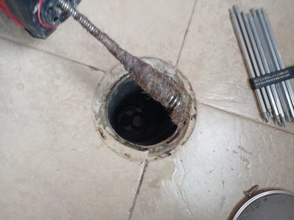 Registro del bote sifónico abierto y equipo de desatasco junto a él