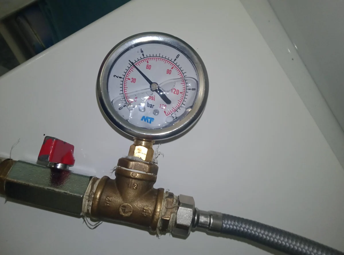 Manómetro conectado a la instalación de agua durante una revisión