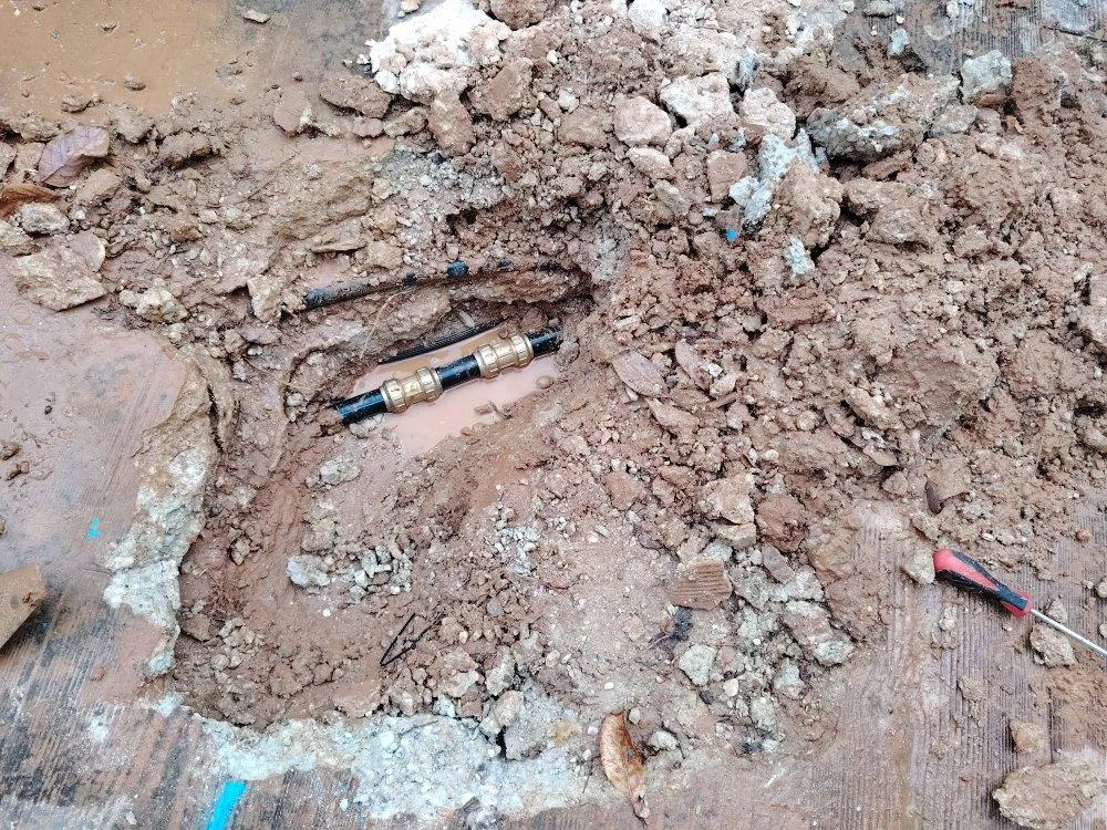 Tramo de conducción reparado dentro de una apertura en el suelo exterior