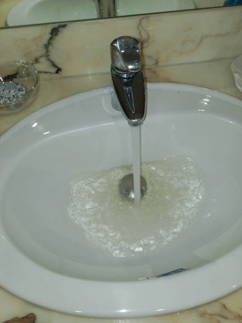 Agua saliendo por el grifo de un lavabo durante una visita de fontanería