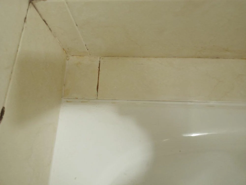 Cordón blanco repuesto en el perímetro de una bañera
