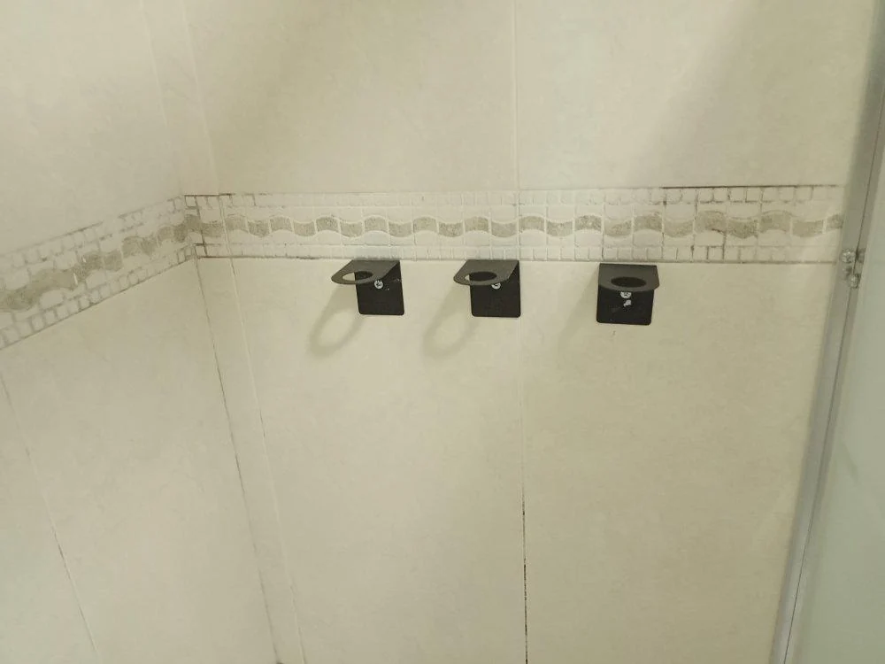 Tres soportes fijados en la pared de un baño