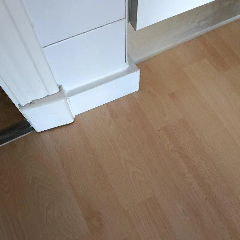 Remate de rodapié junto a una puerta durante una reposición de tarima